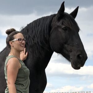 Woman looking with black horse
